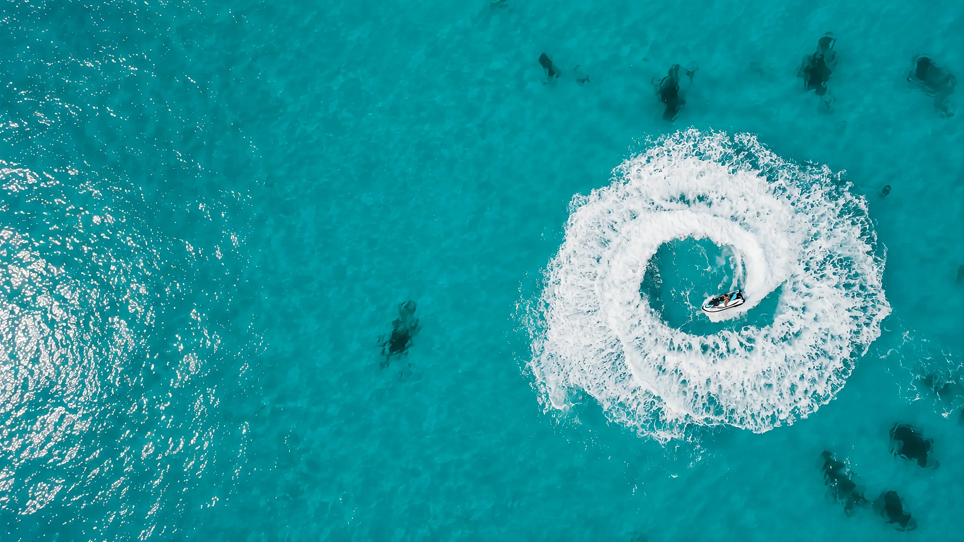 Vista aérea de una moto de agua surcando aguas turquesas del Mediterráneo - Jetski Valencia